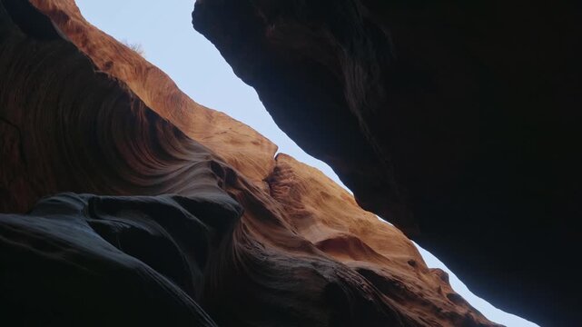 Smooth flowing sandstone textures rise along narrow Buckskin Gulch slot canyon walls beneath open sky, abstract rotate