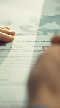 Within high-security archive, government official scrutinizes confidential file stamped with a security seal, confirming its classified status and handling the sensitive material with strict protocol