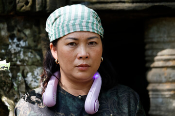 Naklejka premium Unhappy woman wearing the traditional Khmer Krama on her head. Siem Reap. Cambodia.