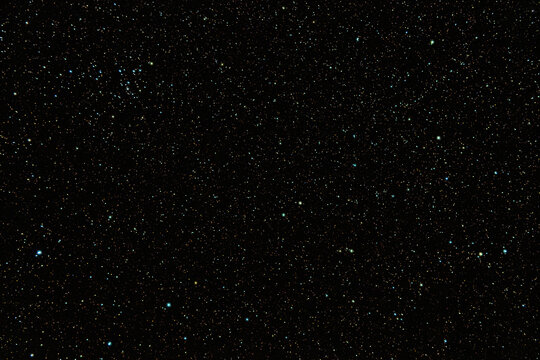 Dense starfield in deep outer space with glowing celestial lights