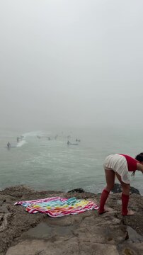 Refined individual balancing on cliffside with surf in sight