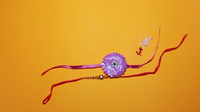 festive raksha bandhan concept with handmade rakhi and traditional rice grains