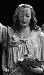 Fototapeta premium Ancient angel statue holding broken object in dramatic monochrome composition
