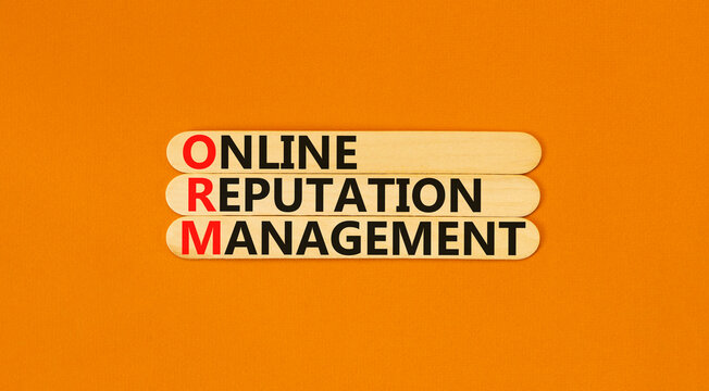 ORM online reputation management symbol. Concept words ORM online reputation management on beautiful wooden sticks. Beautiful orange background. Business ORM concept. Copy space.