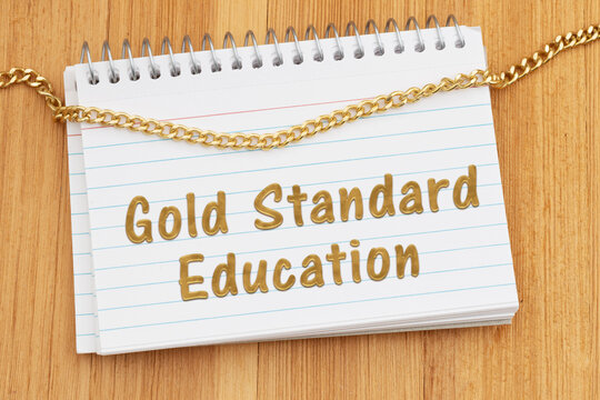Gold Standard Education spiral notebook of index cards with gold chain on wood desk