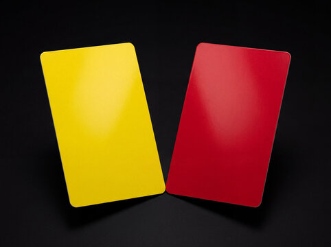 Yellow card (left) and red card (right) side by side, symbolizing penalties, warnings, and expulsion in sports, on black background.