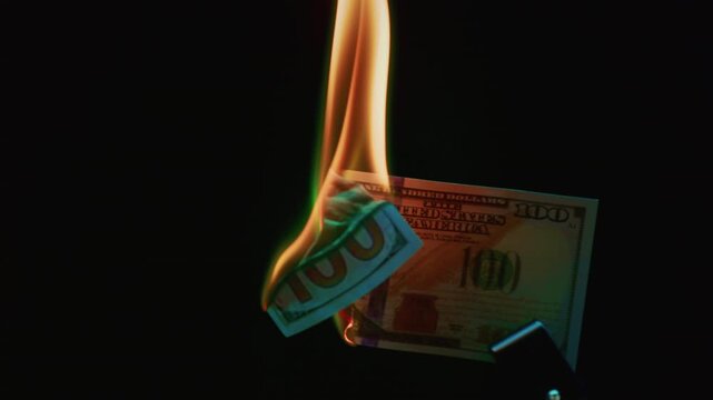 Fire money. Burning 100 bill. Hundred bucks goes up in flames. Collapse of dollar and democracy. End of capitalism, Economic crisis. Burn usd crash. Ignite American paper currency, banknotes.