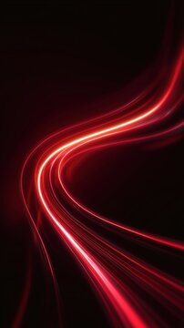 Abstract red light trails on a dark background creating a dynamic and flowing visual effect, suitable for backgrounds or digital designs