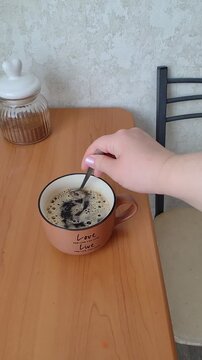 Close-up morning video of hands stirring hot chicory coffee in a mug. Cozy homemade drink, calm breakfast routine, soft natural light and authentic slow living atmosphere.