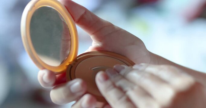 Woman applying powder with a puff from a compact case, soft lighting, beauty and skincare routine concept, minimal and elegant daily makeup moment, Close-up