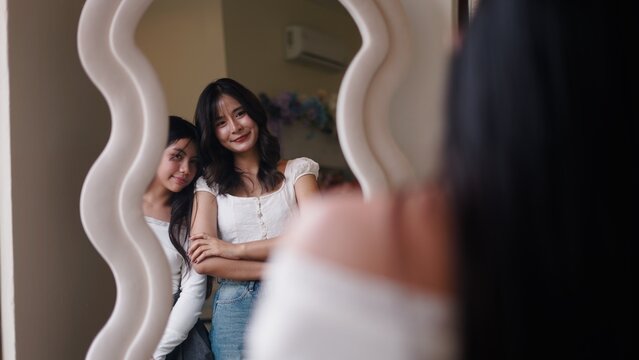 Young friends happily reflecting in a decorative mirror at home