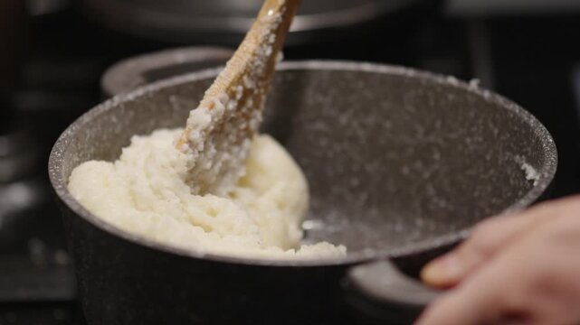 Cooking ghomi, a popular dish from the Samegrelo region made with coarse white corn