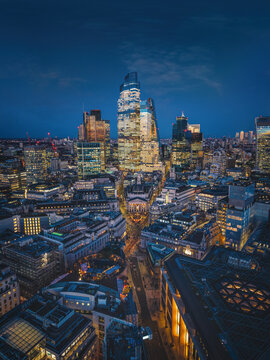 Elevated view of the illuminated City of London, England, skyline with Cornhill and Bank square during evening time