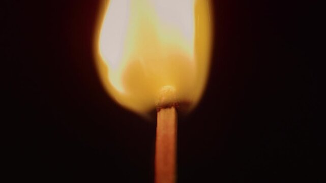 Close-up of striking and lighting a match in dark. Dramatic ignition of a matchstick with glowing flame, sparks and smoke in low light, cinematic fire detail and moody atmosphere.