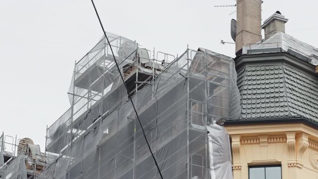 Detailed view of old structure. Closeup of aged turret featuring ornate roof design and ongoing repairs