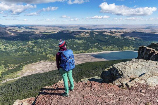 Young hiker standing at the view of mountain lake Lower Two Medicine Lake with mountain landscape, Continental Divide Trail, Sinopah Mountain, Glacier National Park, Montana, USA