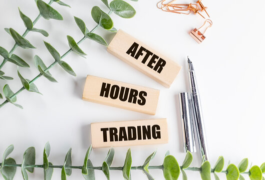 After hours trading concept with wooden blocks pen and office supplies on desk stock market extended session finance