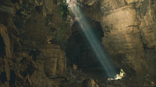Quiet chamber mammoth cave system bathed in meditative beam, ancient stone textures and still air evoke reverent calm and reflective solitude.
