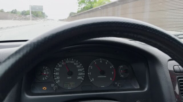 Highresolution footage of car interior featuring steering wheel and dashboard during overcast drive