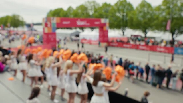 Excited spectators and energetic cheerleaders create lively festival atmosphere at race event