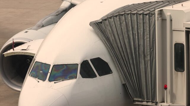 Passenger boarding bridge connected to aircraft at airport terminal