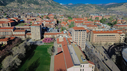 Lawn and foothill alignment near Broadway with academic halls, interior courtyards, walkways leading toward foothill edge neighborhoods. Stone facade, red roofs, scattered trees, Boulder, CO © trongnguyen