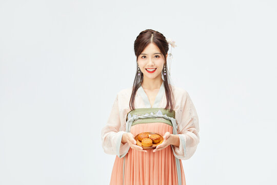 Smiling woman in traditional Chinese hanfu holding mooncakes