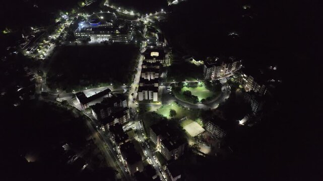 Drone shot of glowing city lights and urban township at night.