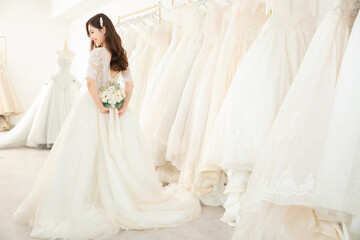 Fototapeta premium Beautiful bride holding bouquet in bridal boutique