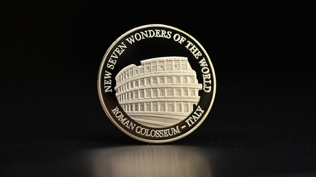 A collection of gold commemorative coins featuring the New Seven Wonders of the World. On one side is the Roman Colosseum