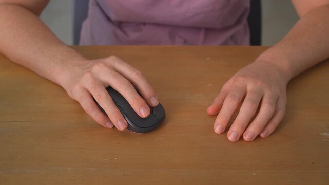 Close up woman clicking wireless computer mouse with clear sound. Hand operating device at desk. Technology use, office work, productivity and everyday routine concept