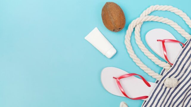 Summer beach essentials laid out on a bright blue background for vacation