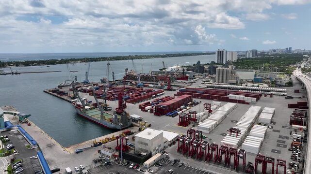 Drone shot of industrial shipping terminal with stacks of cargo containers  at Port of Palm Beach Florida on a Hazy Overcast Day  (Fly Foward)
