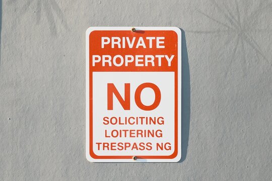 Private property sign on textured wall with no trespassing text