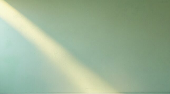 A soft diagonal beam of sunlight illuminating a plain neutral background