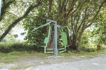 Fototapeta premium Chest Press / Seated Row Combo Station - Outdoor Gym, Santa Comba Dão, Portugal, public fitness Calisthenics equipment in a green park environment