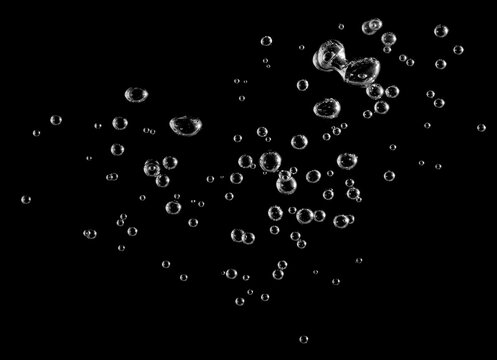 Abstract underwater air bubbles isolated on black background, transparent oxygen spheres floating in liquid, macro splash texture for science, freshness, purity, beverage, and design concepts.