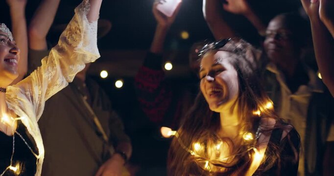 Festival friends, night and outdoor with dancing with group at party and event in the dark. Freedom, social and female person at concert with dj and music in a crowd with celebration and rave song