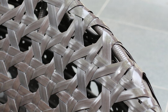 Close-up of dark brown woven rattan texture on outdoor furniture