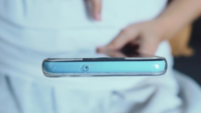 Person holding a mobile smartphone, a finger touching the responsive screen while navigating an application, symbolizing modern digital connectivity and communication technology