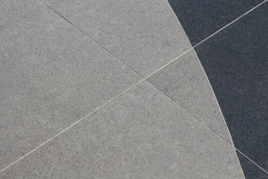 Abstract pattern of contrasting grey and dark grey textured tiles with clean grout lines