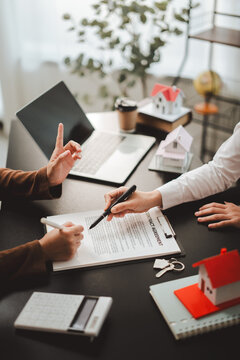 Client signing a real estate contract for a home purchase or mortgage agreement, working with an agent or broker completing the property transaction