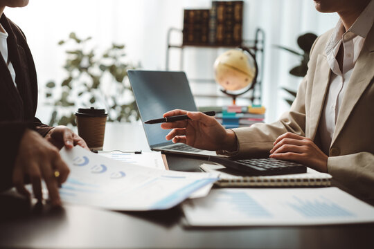 Business partners analyzing financial data and discussing company performance during an office meeting, collaborating on strategy and planning future growth and investment