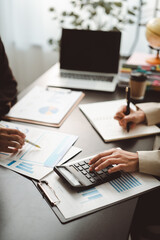 Fototapeta premium Professionals analyzing financial data, calculating budget, and taking notes during a business meeting, collaborating on investment strategy and accounting audit