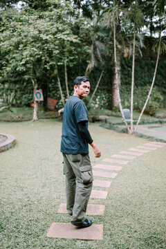Southeast Asian Man Standing Outdoors Looking Back at Camera