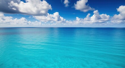 Fototapeta premium Vast turquoise ocean surface under a beautiful sky with fluffy white cumulus clouds