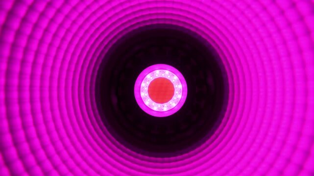 Macro view of a bright red LED ring lamp featuring textured concentric circles and surface mount diode elements. A technology concept depicting modern illumination.