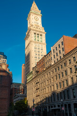 Fototapeta premium Vertical view of the Boston Custom house tower at downtown showing the iconic clock and neoclassical architecture alongside classic facades of the city.
