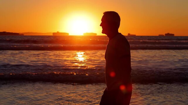 64 year old man getting his exercise at the beach at sunset. Slow Motion.