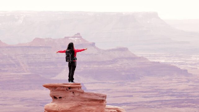 Asian woman hiking through the amazing landscape near Moab Utah, USA.